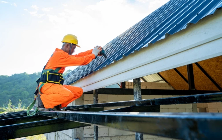 robotnik układający dachówki